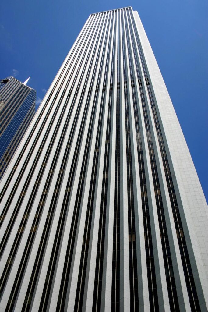 Zoomed in view from street level looking up at Aon Building showing the vertical lines of white mount airy granite facade panels and glass windows between