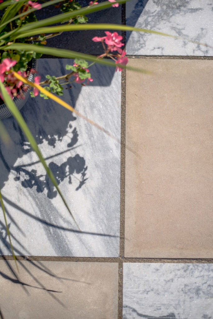 A striking checkerboard patio designed by Jaclyn Isaac using Indiana Limestone and Georgia Marble, forming the centerpiece of her outdoor living space